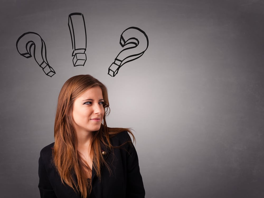 Beautiful young lady thinking with question marks overhead-1