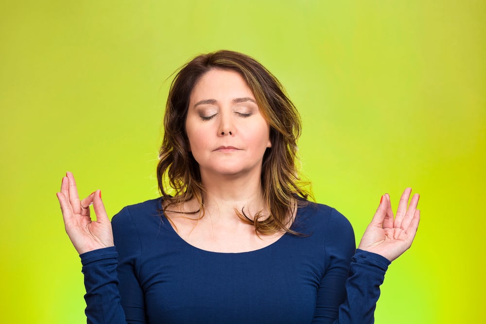 Closeup portrait peaceful young woman relaxing, meditating, in zen mode, isolated green background. Positive human emotions, facial expressions, attitude, life perception, situation, symbols, approach