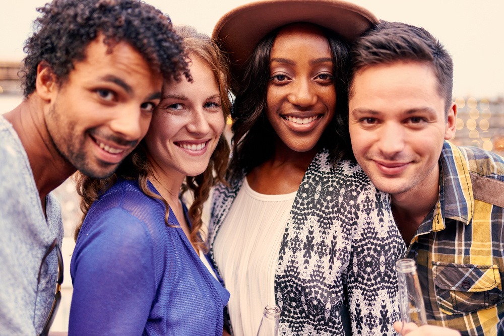 Multi-ethnic millenial group of friends taking a selfie photo with mobile phone on rooftop terrasse at sunset-2