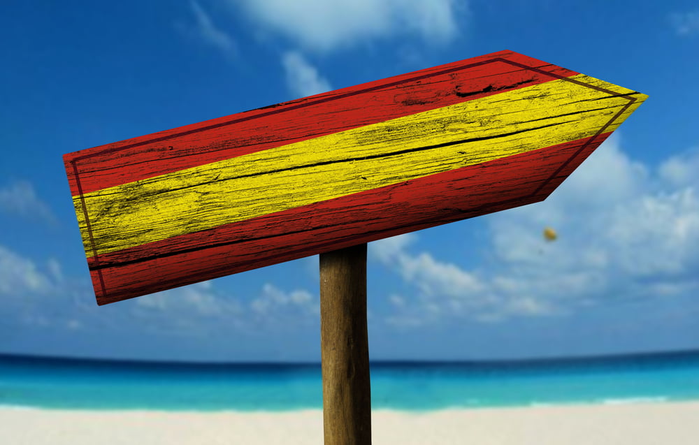 Spain flag wooden sign with a beach on background - Europe