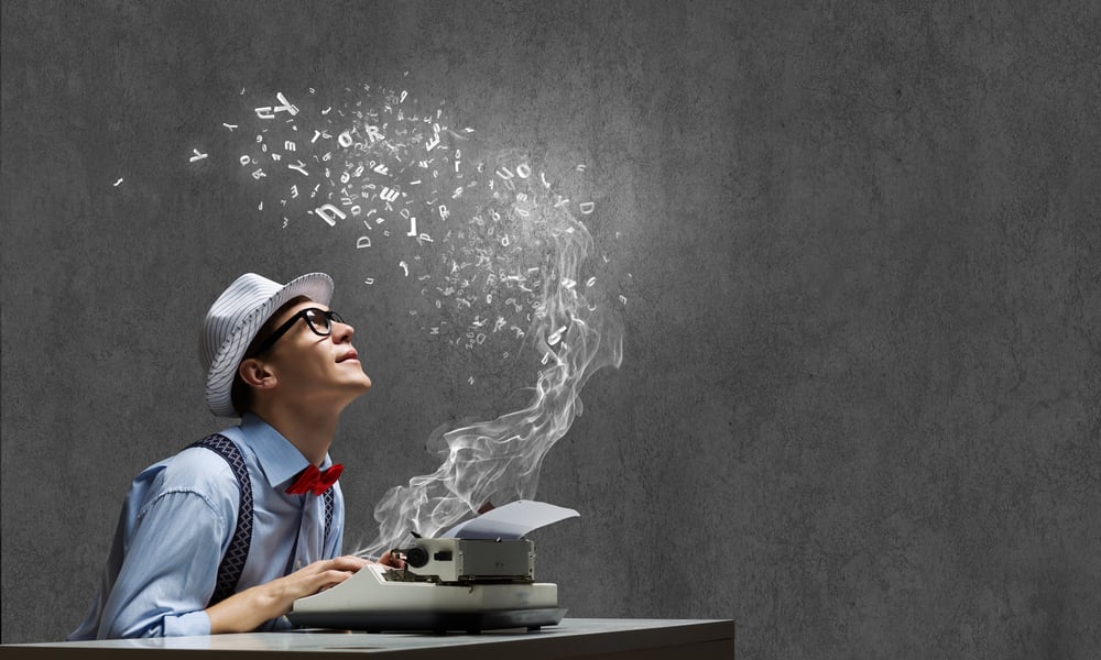 Young funny man in glasses writing on typewriter-1